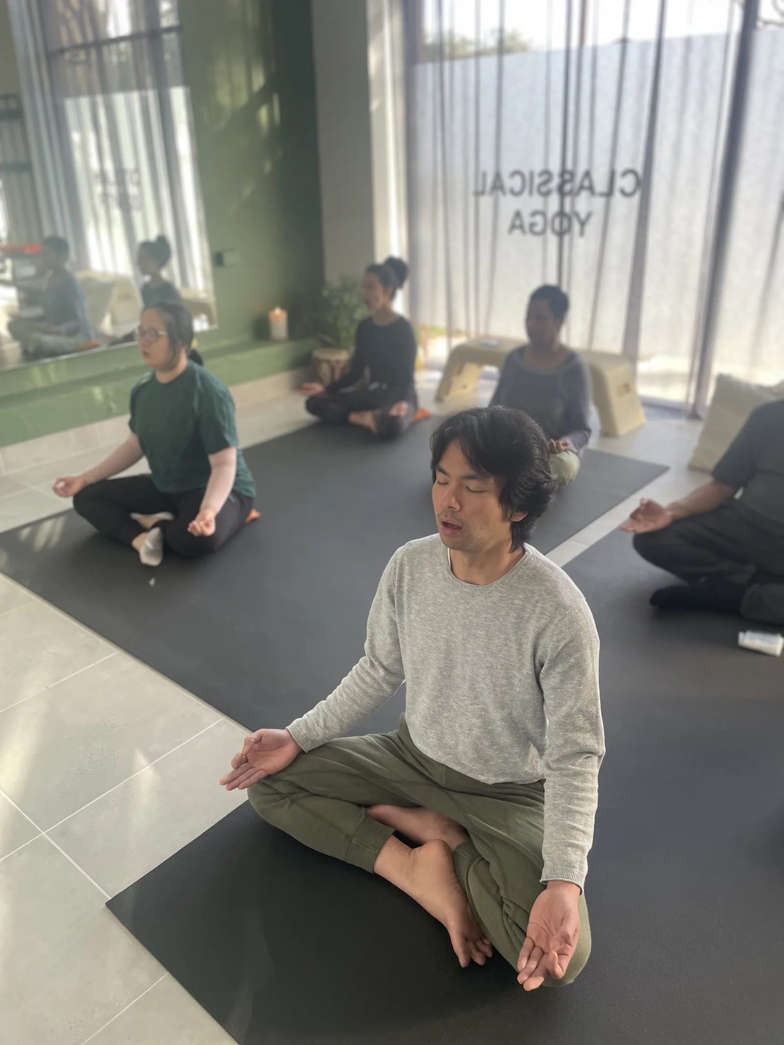 A teacher guiding a student one to one during a classical yoga class at the Adiyoga studio in Earlwood